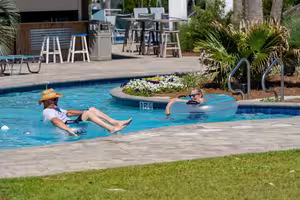 Adults relaxing in the pool near the swim-up bar at Splash RV Resort