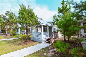 A coastal-style luxury cottage with a covered porch at Splash RV Resort near Pensacola