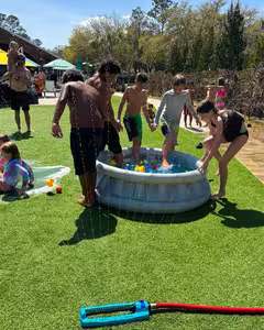 Children playing in the water on the lawn at a family event at Splash RV Resort