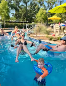 Family floating on inflatable tubes down the lazy river at Splash RV Resort near Pensacola