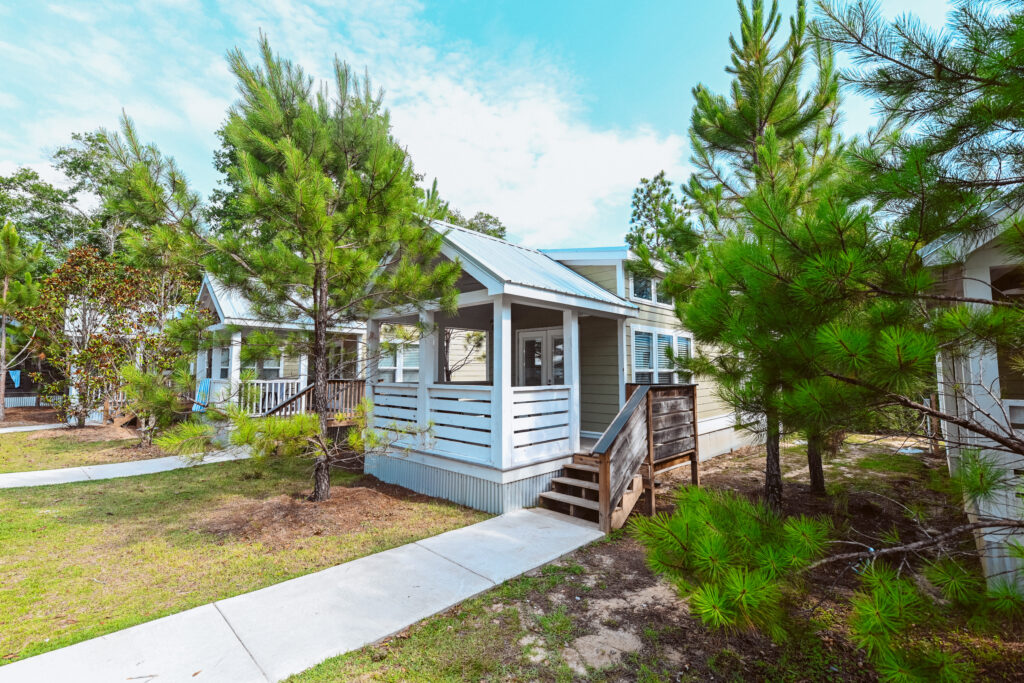 Coastal-style luxury cottage with a covered front porch at Splash RV Resort
