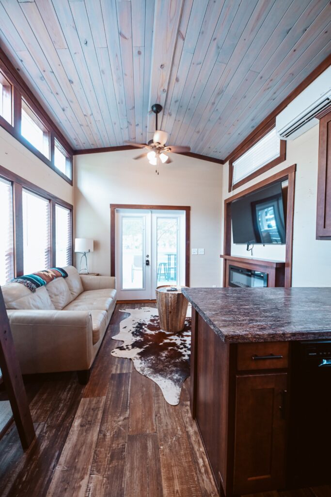 Inside a luxury cottage at Splash RV Resort with vaulted wood ceiling, kitchen, and AC near Pensacola