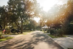 Golden-hour light filtering through oak trees over a paved road and full-hookup RV sites at Splash RV Resort in Milton, Florida.