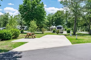 A spacious shaded all-concrete RV site with a picnic table at Splash RV Resort, an Emerald Coast basecamp near Fort Walton Beach