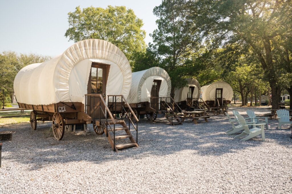Row of Conestoga-style glamping wagons at Splash RV Resort near Pensacola