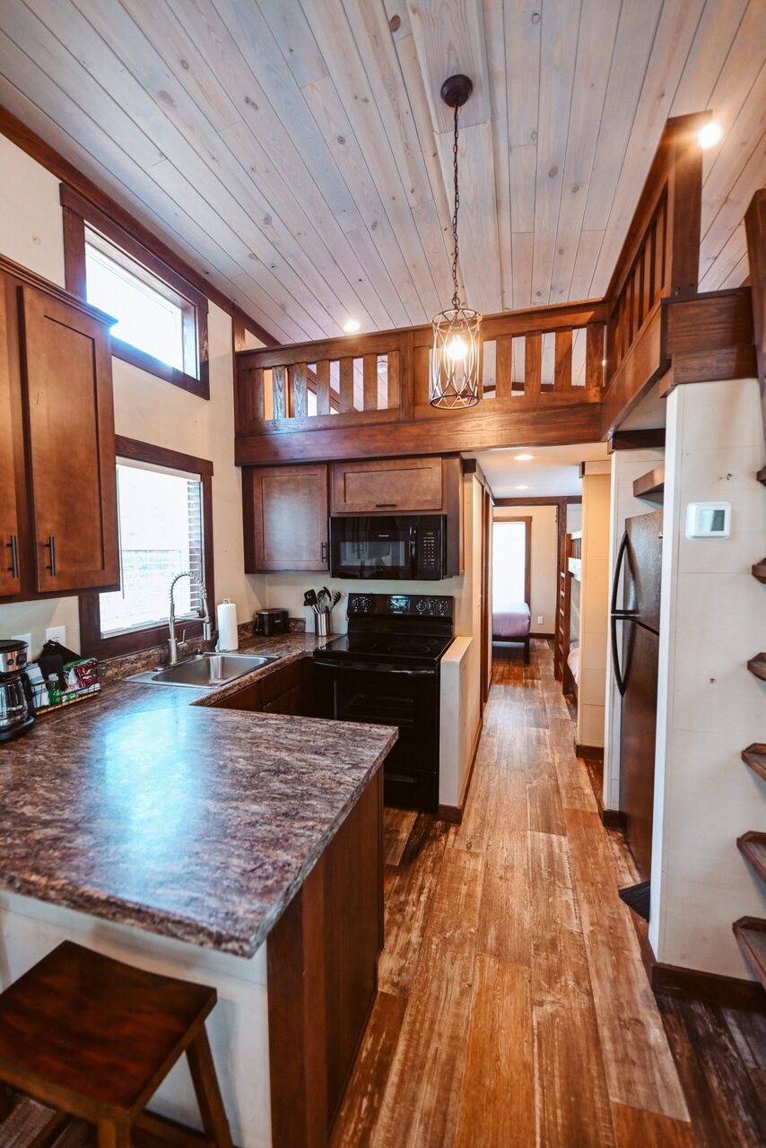 Full kitchen with stove, oven, microwave and refrigerator in a cabin at Splash RV Resort near Navarre Beach