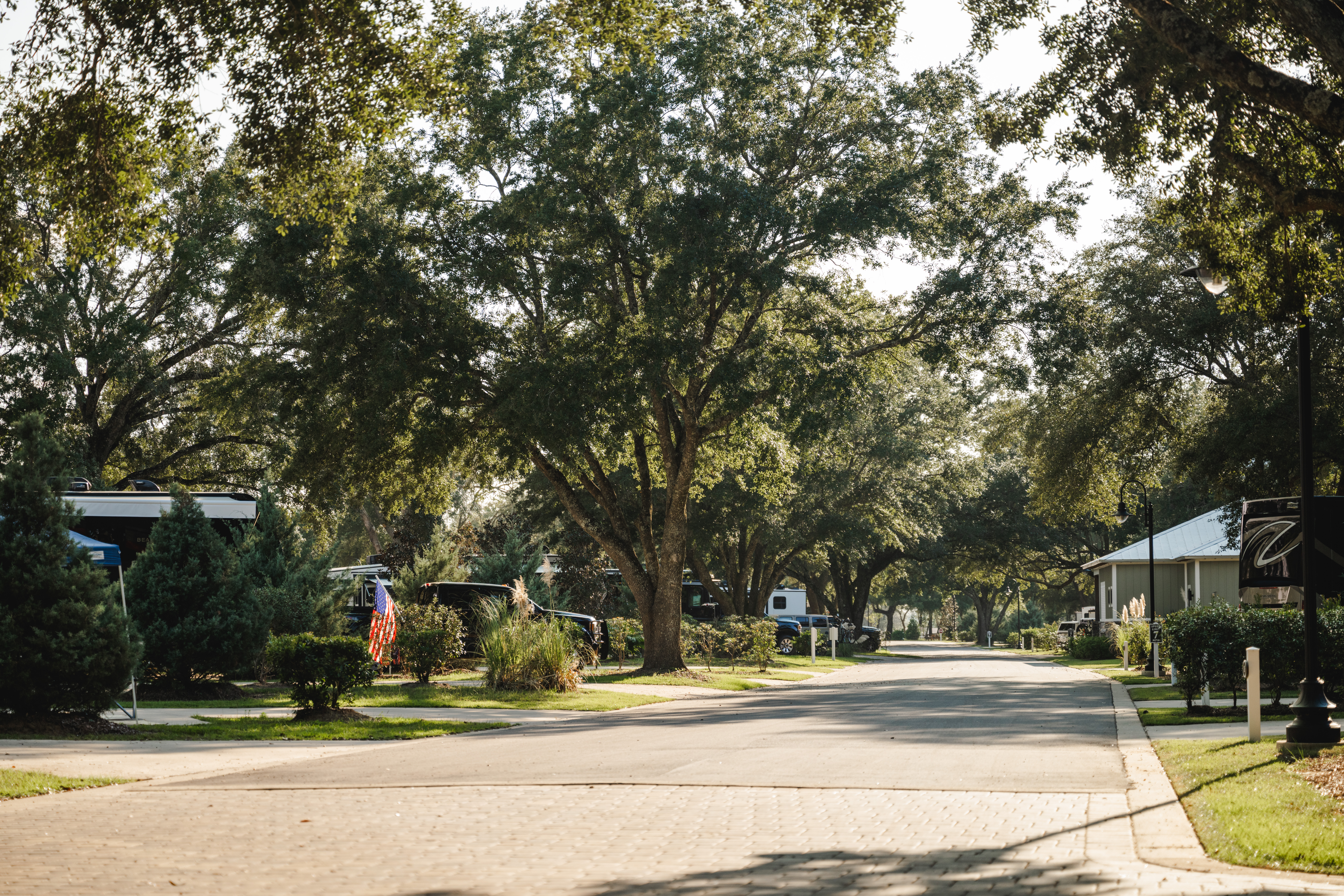 Paved concrete full-hookup RV sites shaded by oak trees at Splash RV Resort in Milton FL