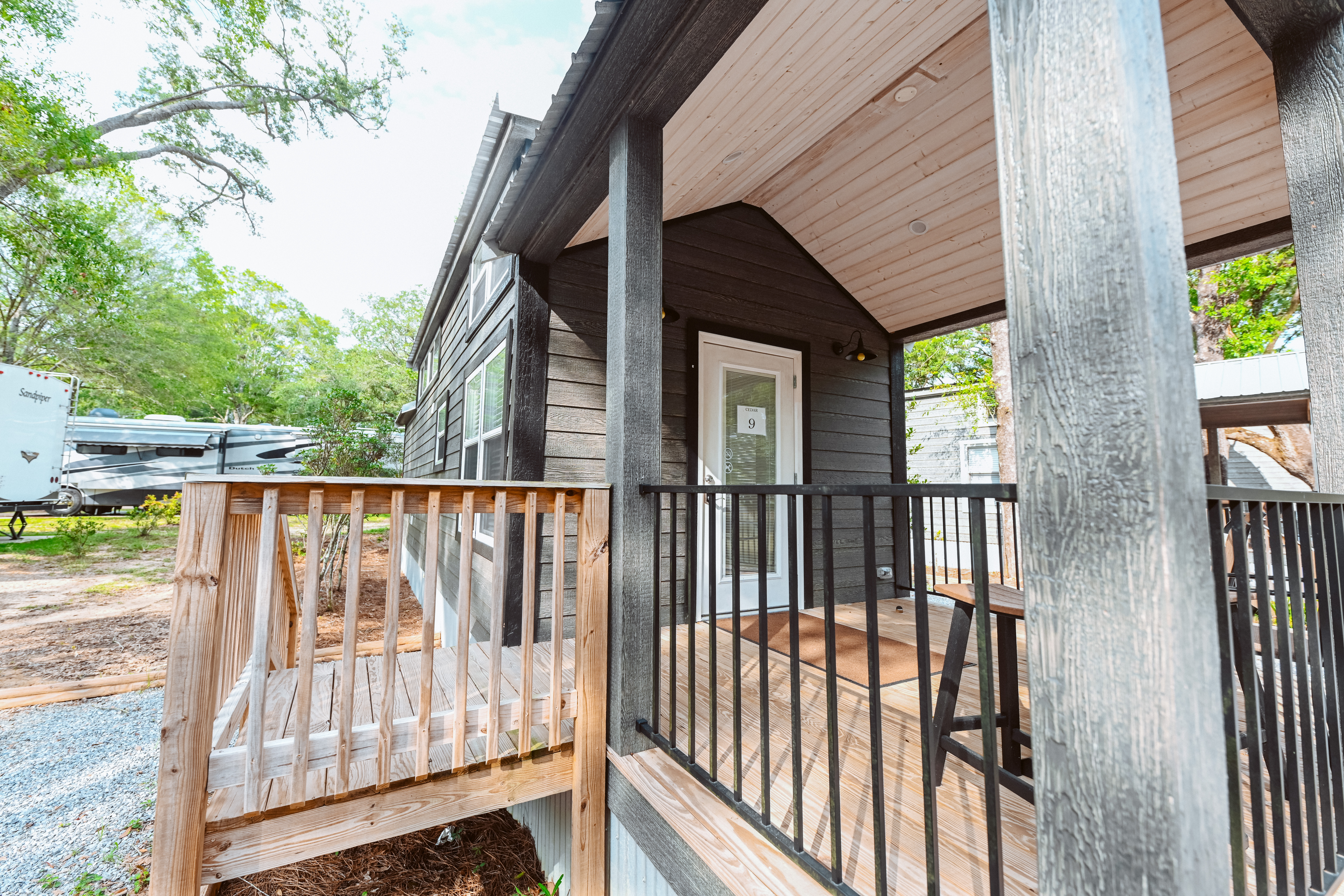 Exterior of a luxury cottage with a covered porch at Splash RV Resort near Navarre Beach