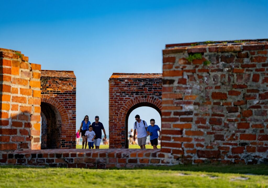 A family walks through the historic brick archways of Fort Pickens at Gulf Islands National Seashore near Pensacola, Florida