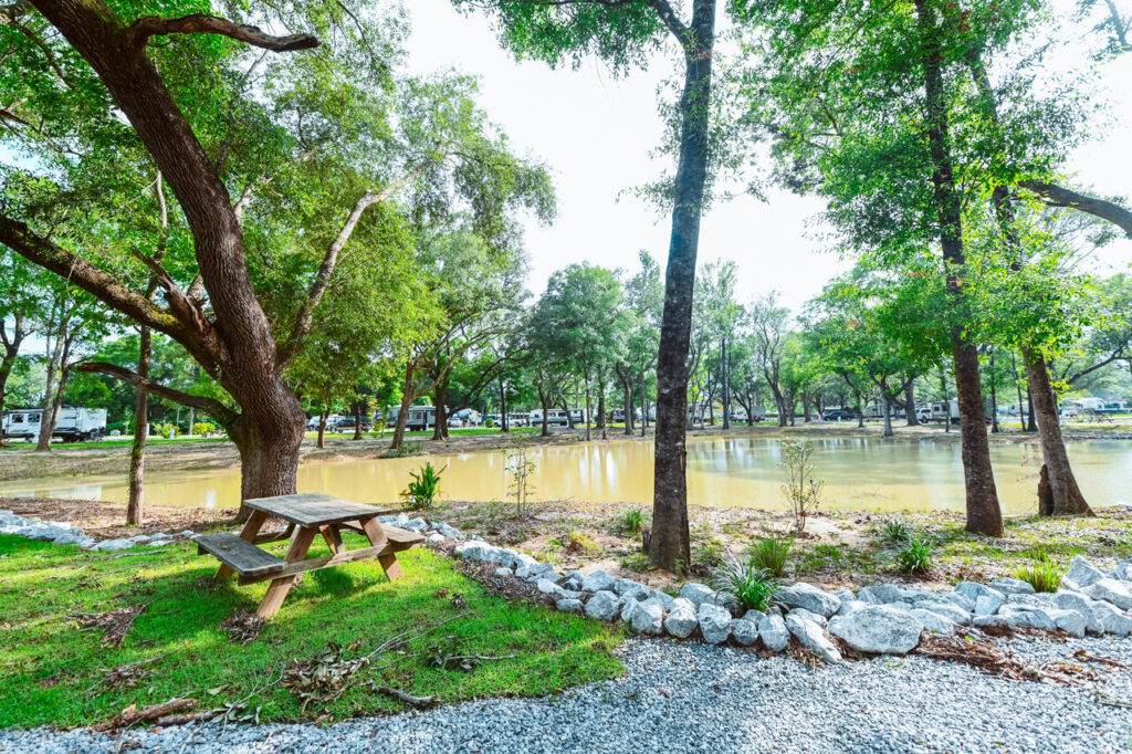 Shaded natural grounds with mature trees and a pond at Splash RV Resort near Navarre Beach FL
