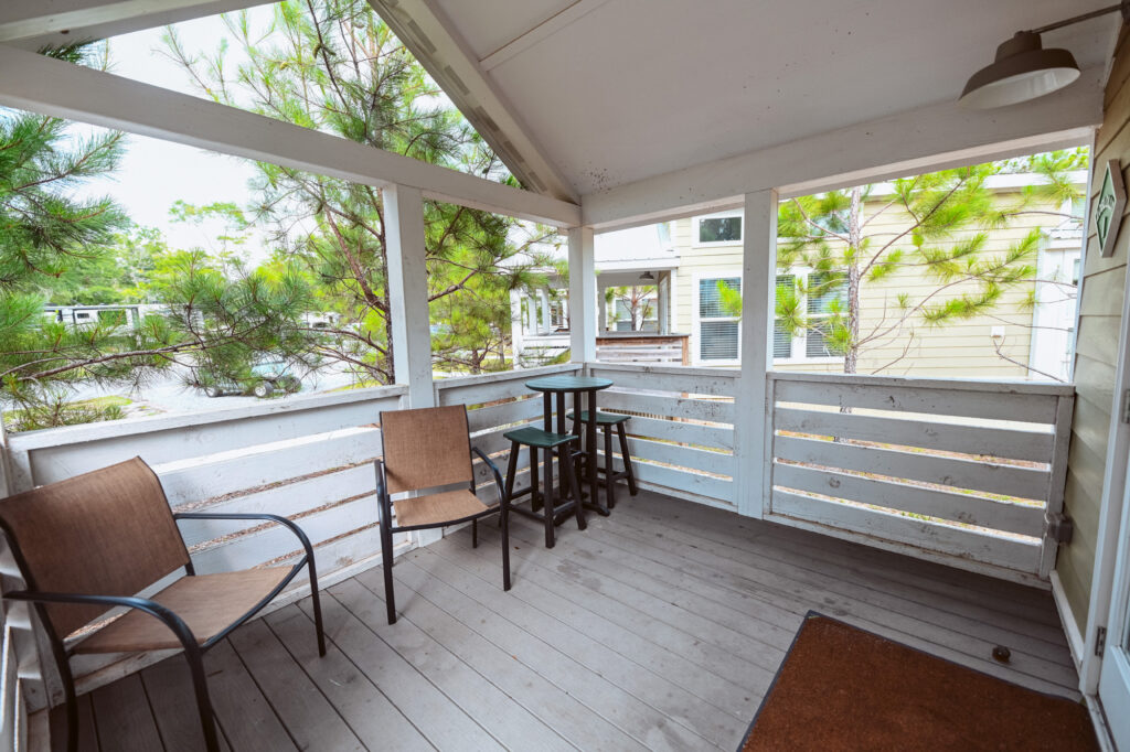 A cottage porch with outdoor seating at a winter RV resort near Pensacola