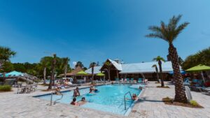 Pool and palm-lined sun deck at Splash RV Resort near Gulf Breeze FL