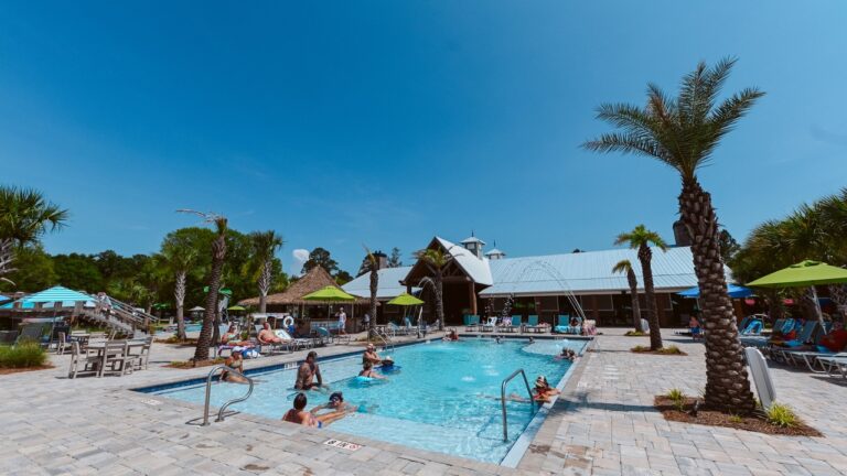 Pool and palm-lined sun deck at Splash RV Resort near Gulf Breeze FL