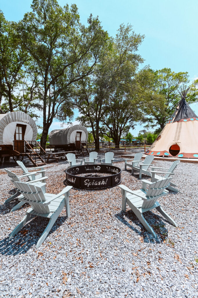 Conestoga-style glamping wagons and a fire pit at Splash RV Resort near Gulf Breeze FL