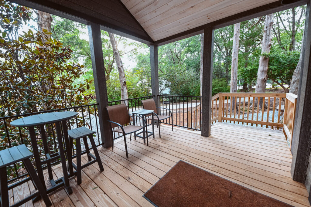 Covered deck of a luxury cottage surrounded by pines at Splash RV Resort near Gulf Breeze FL