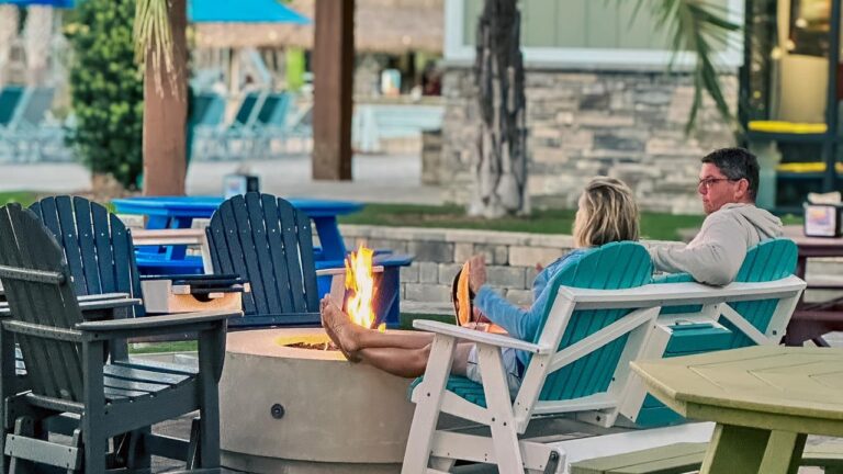 Couple by an evening fire pit at an RV resort near Fort Walton Beach FL