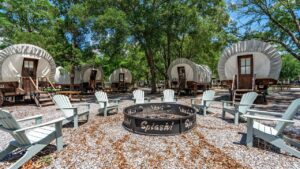 Covered wagons around a fire pit at Splash RV Resort near Pensacola FL