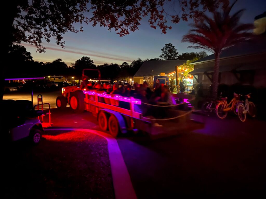 A hayride wagon lit with purple lights at dusk at Splash RV Resort near Pensacola