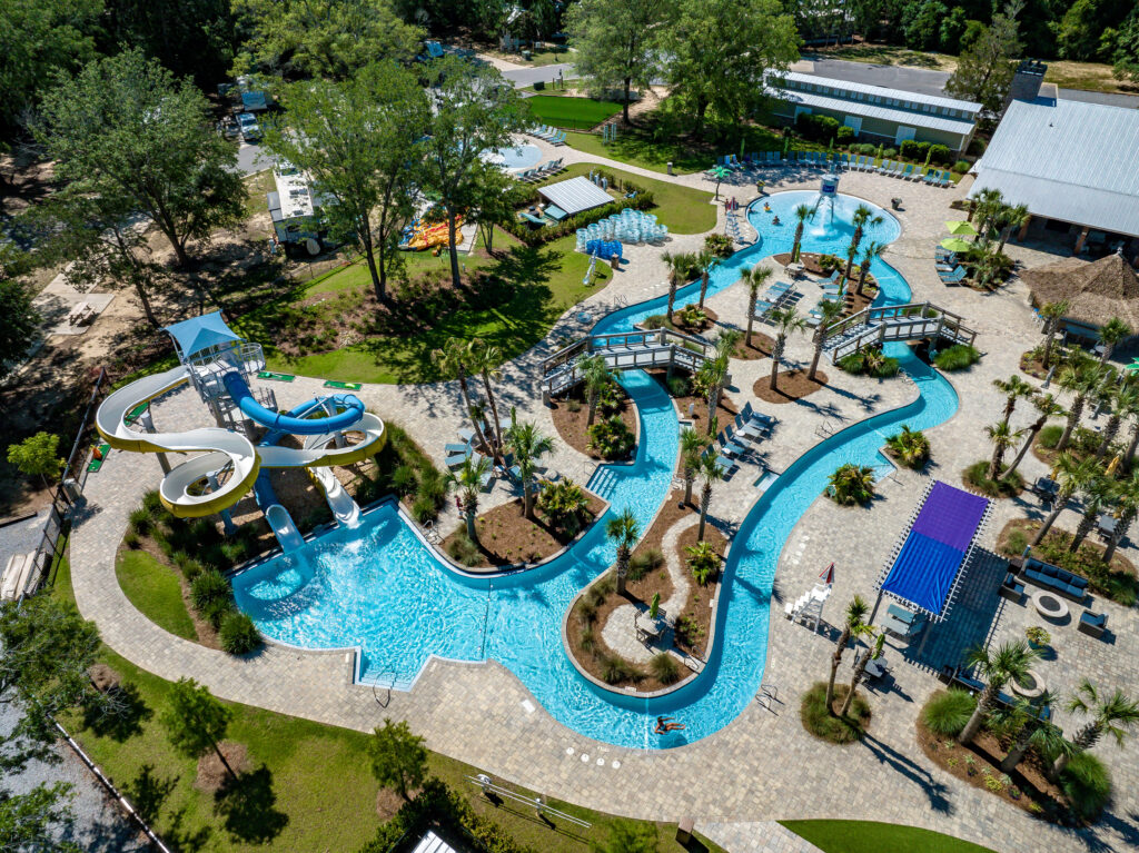Aerial view of the lazy river, water slides and palm-lined pool deck at Splash RV Resort in Milton, Florida