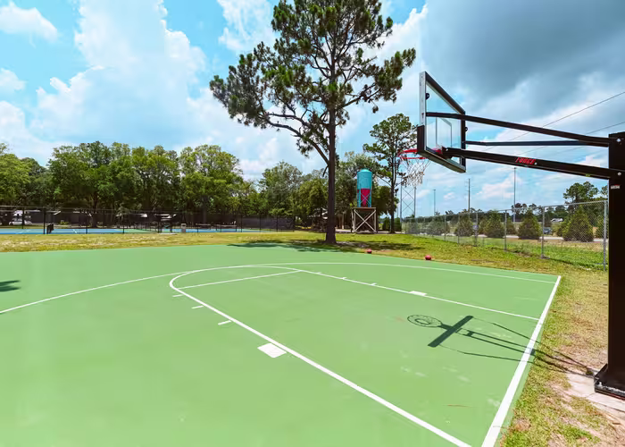 Outdoor basketball court at Splash RV Resort with green surface and Forge hoop.