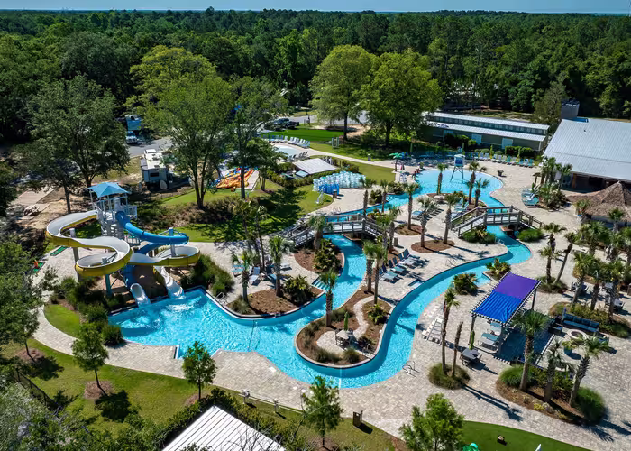 Aerial view of Splash RV Resort water attractions featuring a winding lazy river, swimming pool, and tall yellow and blue