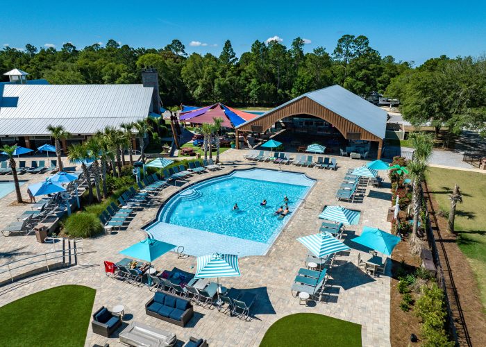 Aerial view of the Splash RV Resort swimming pool and pavilion, surrounded by lounge chairs and umbrellas.