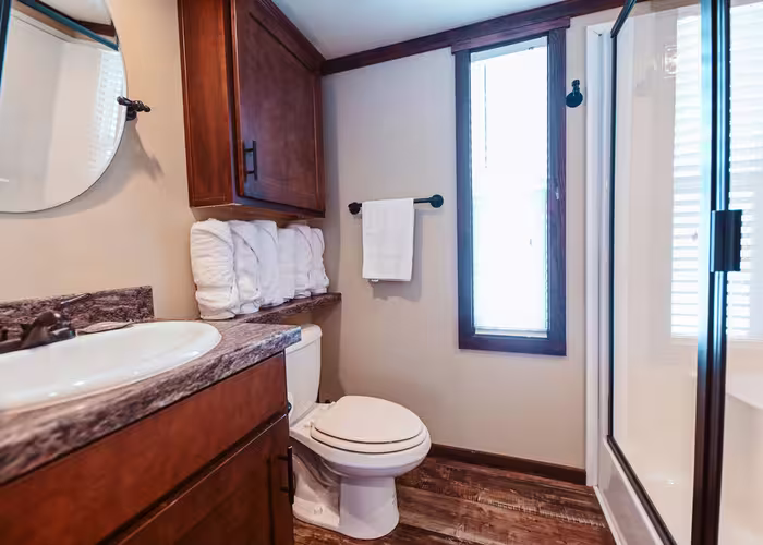 Bathroom with dark wood cabinetry and granite vanity at Splash RV Resort in Milton, Florida.