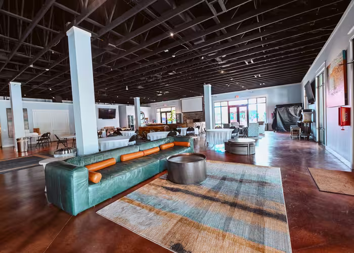 Teal leather sofa and orange pillows in the Splash RV Resort clubhouse lounge area