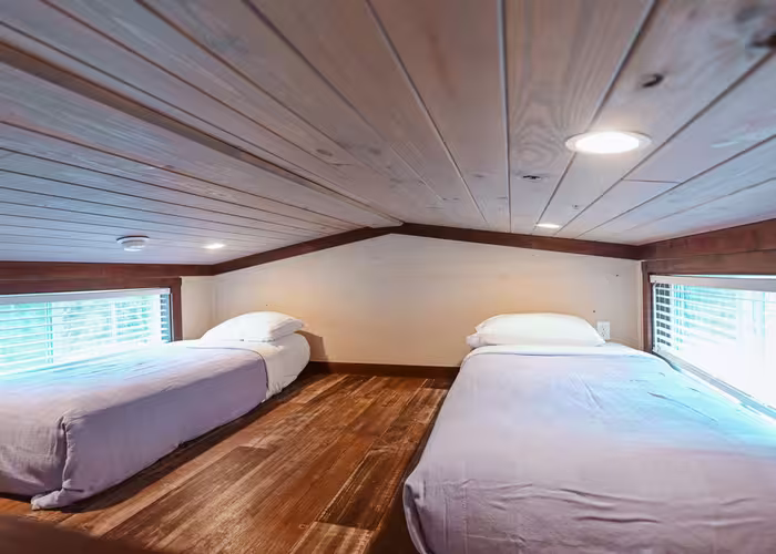 Loft bedroom with twin beds beneath shiplap ceiling at Splash RV Resort in Milton, Florida.
