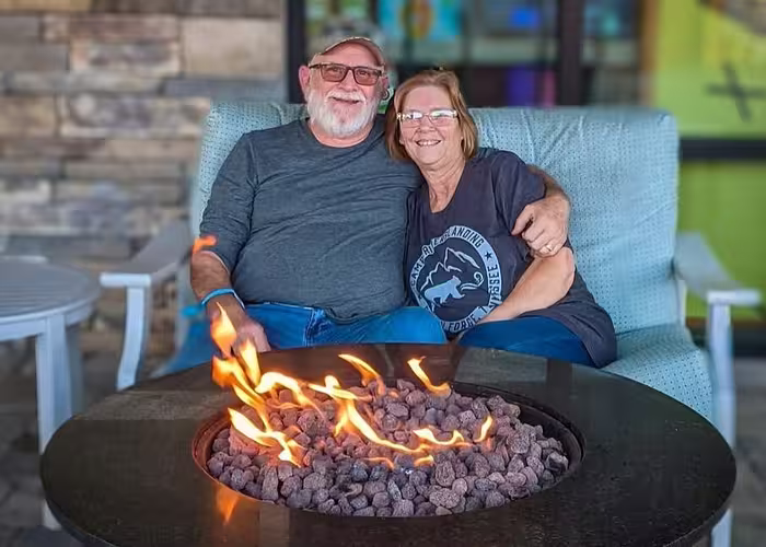 Couple relaxing by a fire pit at Splash RV Resort