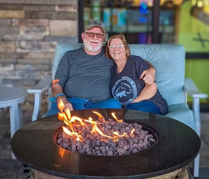 Couple relaxing by a fire pit at Splash RV Resort