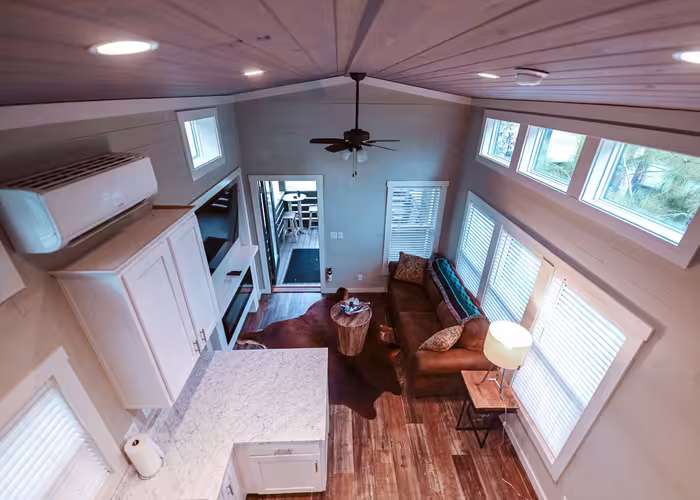 Interior of a glamping wagon at Splash RV Resort with a sofa, kitchenette, and vaulted ceiling.