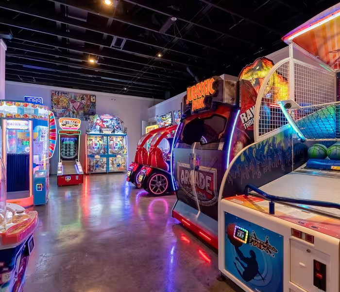 Colorful arcade games and racing simulators in the Splash RV Resort indoor arcade.