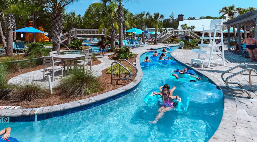 Guests float along the winding lazy river on bright blue inner tubes at Splash RV Resort in Milton, Florida