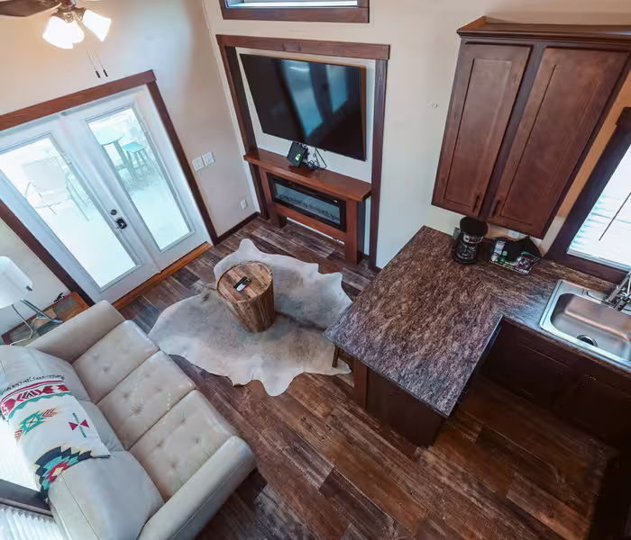 Open-concept loft living space with leather sofa and electric fireplace at Splash RV Resort in Milton, Florida.