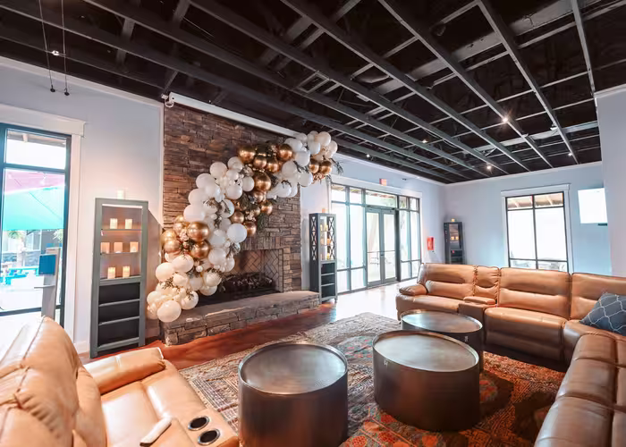 Elegant lounge with stacked-stone fireplace and balloon garland at Splash RV Resort in Milton, Florida.