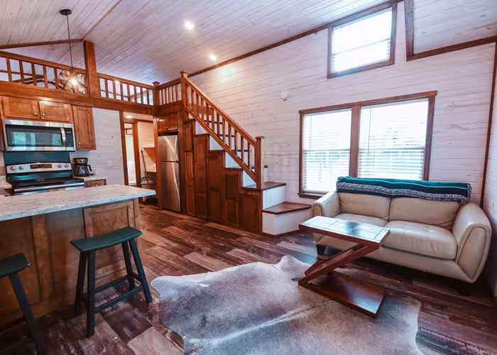 Spacious luxury cabin interior at Splash RV Resort with kitchen, sofa, and loft.