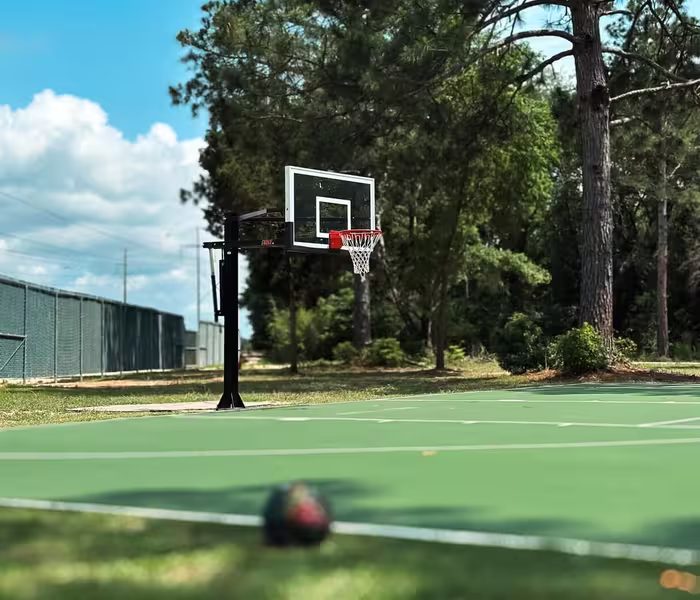 Outdoor basketball court at Splash RV Resort with hoop and ball on green surface