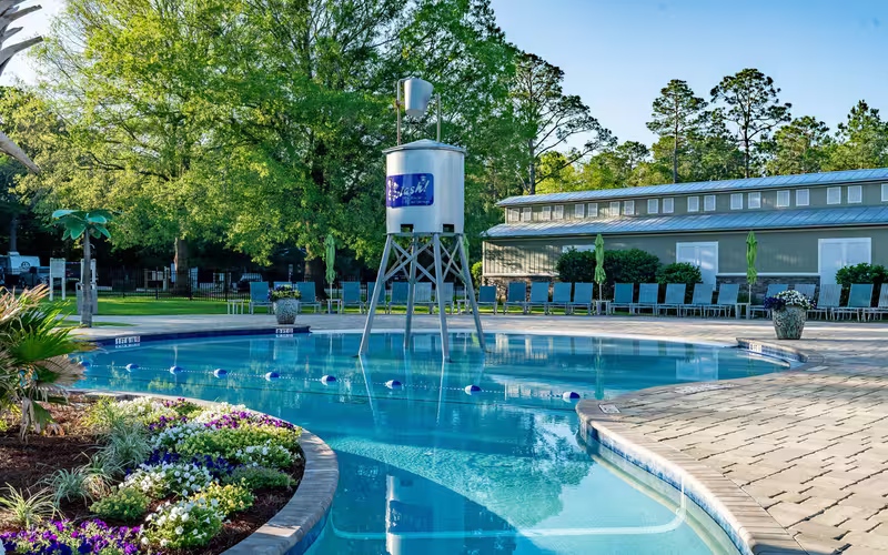 Splash RV Resort swimming pool with a central water tower and lounge chairs on the deck.