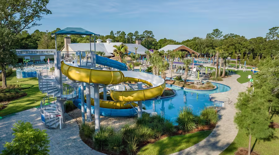 Aerial view of a yellow and blue water slide at Splash RV Resort next to a swimming pool.